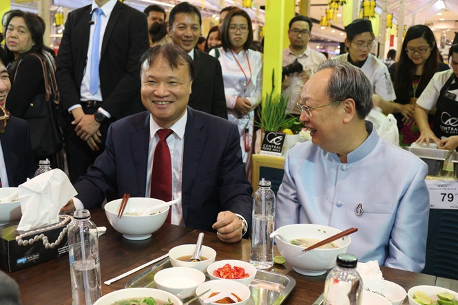 Thứ trưởng Bộ Công thương Việt Nam Đỗ Thắng Hải (trái) và Bộ trưởng Bộ Thương mại Thái Lan Sontirat Sontijirawong đang dùng món phở Việt tại tuần hàng Việt 2018